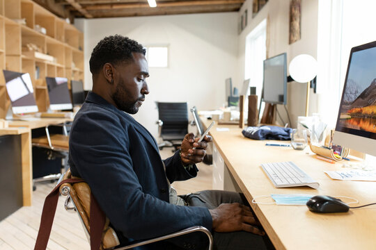 Man in startup business texting in workspace