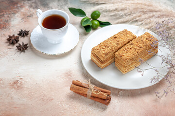 front view tasty cake slices with tea on light desk sweet cake pie biscuits