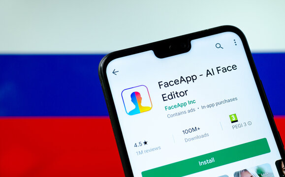 Stone, Staffordshire / United Kingdom - July 21 2019: FaceApp logo on the screen of smartphone with the flag of Russia at the blurred background behind it. Conceptual editorial illustrative photo.