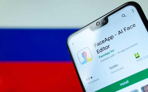 Stone, Staffordshire / United Kingdom - July 21 2019: FaceApp logo on the screen of smartphone with the flag of Russia at the blurred background behind it. Conceptual editorial illustrative photo.