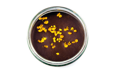 Luxurious cheese cake dessert in a glass jar with edible gold flakes on top of it. Isolated on white.