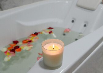 Fototapeta na wymiar a relaxing candle and rose petals in a bathroom