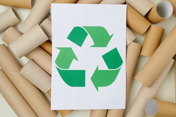 flat lay with recycle sign, toilet paper tubes and paper sheet