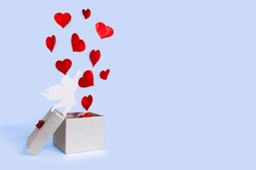 open silver gift box with flying out hearts and cupid on blue background. levitation. happy valentines day. symbol of 14 February. copy space, place for text.