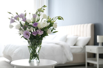 Beautiful bouquet with Eustoma flowers on table in bedroom. Space for text