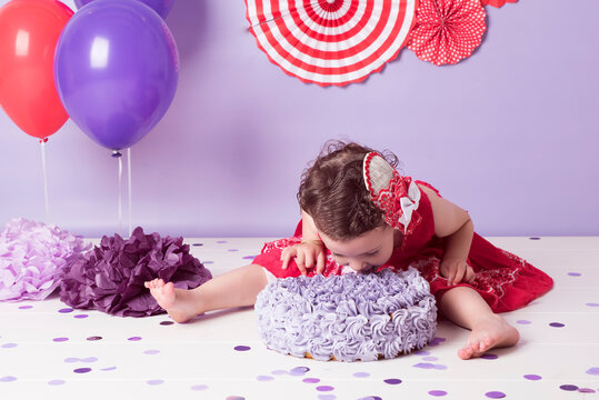 Ni&ntilde;a come tarta de cumplea&ntilde;os con vestido rojo y decorado con globos y confeti