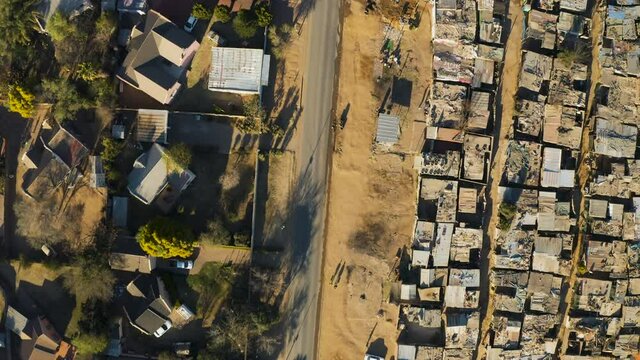 Inequality.Aerial close-up straight down view of an informal settlement Kya Sands squatter camp right next to middle class suburban housing, Gauteng Province, South Africa