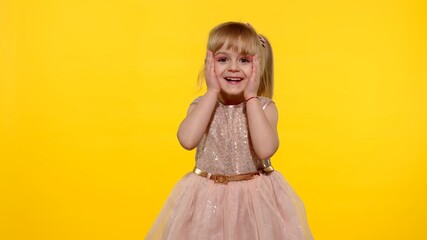 Wow reaction. Portrait of happy amazed astonished young kid girl in shiny dress isolated on yellow copy space background. Impressed child. Perfect surprise. Exciting news