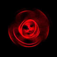 Spinning rays of light isolated on black background. Graphic 2D illustration of glowing colorful light particles in circular motion.