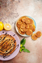 Vertical view of simple and decorated classic pancakes fruits on colourful background