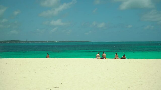 Tropical beach with tourists and clear blue sea. Summer and travel vacation concept. Daco, Philippines