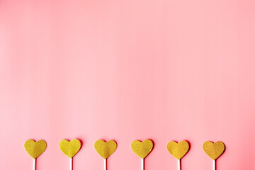 Obraz premium gold hearts on pink paper background. happy valentine's day, minimalism concept