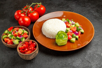 Close up view of homemade rice dish and vegetables on dark background