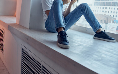 A man sits on a windowsill rest interior studio