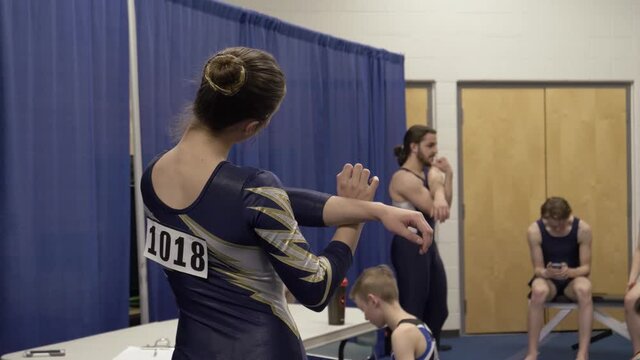 Female gymnast stretching backstage