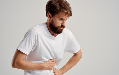 a man is in pain and touches his hand on a light background