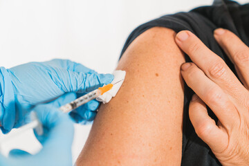Covid vaccine. Doctor performs a vaccination on the patient's shoulder. Physician vaccinating a patient's shoulder. Influenza vaccination. Injection in the Arm. Injecting the coronavirus. Covid-19