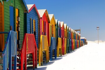 Bunte farbenfrohe Badehäuschen in Muizenberg Kapstadt Cape Town Südafrika am Strand vor blauem Himmel bei Sonne 