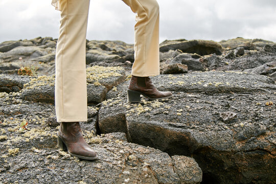 cowboy boots standing on volcano lava field
