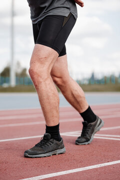 Male runner standing at start line on track