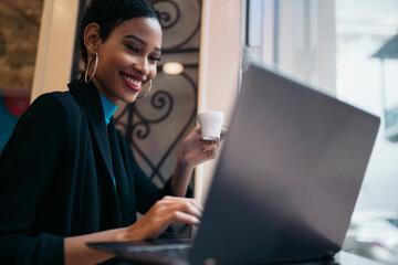 Afro woman using laptop in the restaurant