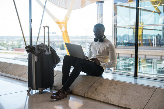 young black businessman using his laptop at the airport waiting for his flight