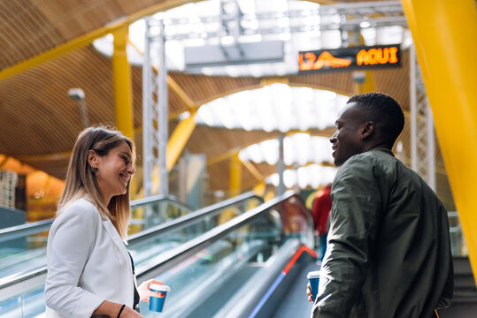young multiracial couple on the walkway at the airport with luggage
