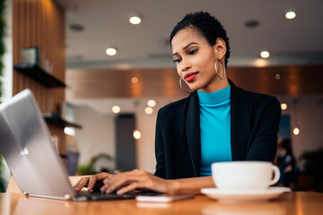 Afro woman using laptop in the restaurant
