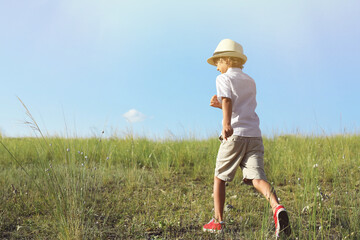 Cute little boy wearing stylish hat outdoors, space for text. Child spending time in nature