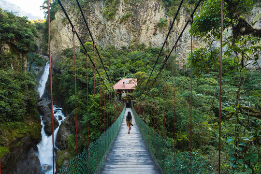 Woman walking in the middle of a wooden bridge in a waterfall