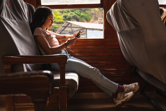 Girl using the mobile in front of the window