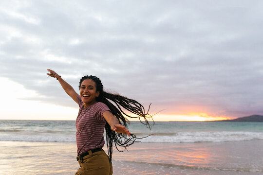 Fototapeta Girl with her arms raised on a beach