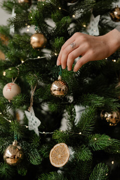 Crop woman decorating Christmas tree