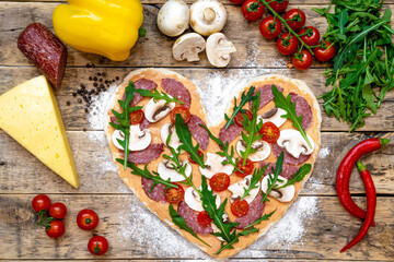 pizza in the shape of a heart and ingredients for Valentine's day, cooking process