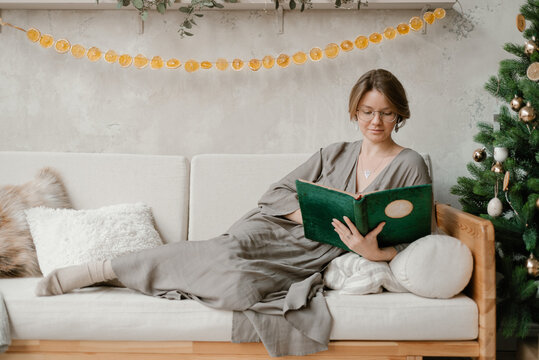 Young woman reading book on Christmas Day