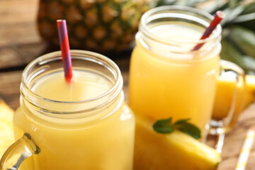 Delicious fresh pineapple juice on wooden table, closeup