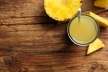 Fototapeta na wymiar Delicious fresh pineapple juice on wooden table, flat lay. Space for text