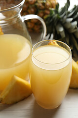 Delicious fresh pineapple juice on white wooden table, closeup
