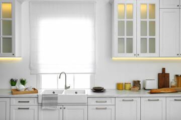 Fototapeta na wymiar Modern kitchen interior with stylish white furniture