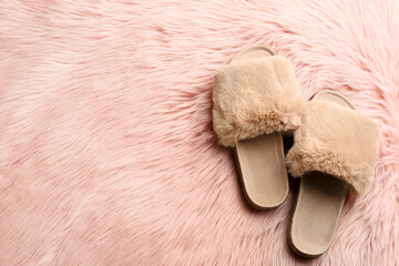 Fototapeta na wymiar Pair of soft slippers on pink faux fur, flat lay. Space for text