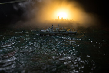 Silhouettes of a crowd standing at blurred military war ship on foggy background. Selective focus....