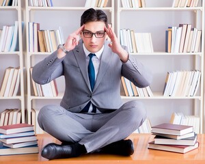 Businessman student in lotus position concentrating in the libr