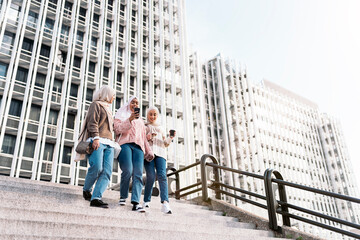 Three muslim women walking down stairs.