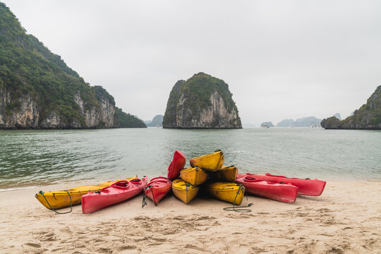 Canoes piled up on a white sand beach