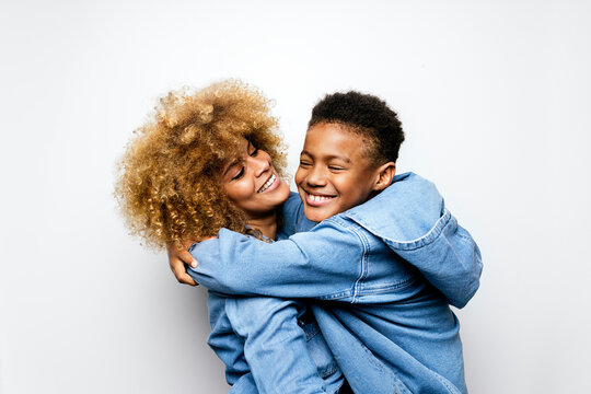 Black boy in studio hugging his mom.