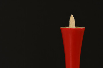 Red Japanese candle on black background.
