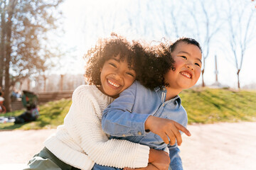 Multiethnic children hugging at the park.