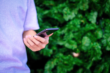 Man holding smartphone with christmas tree background, Technology concept.