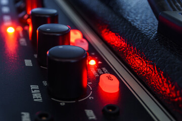 Detail of an amplifier for electric guitar with red lights