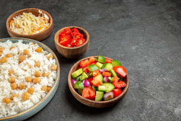 Peas and rice for dinner and sauerkraut and chopped tomato with salad on dark table stock image
